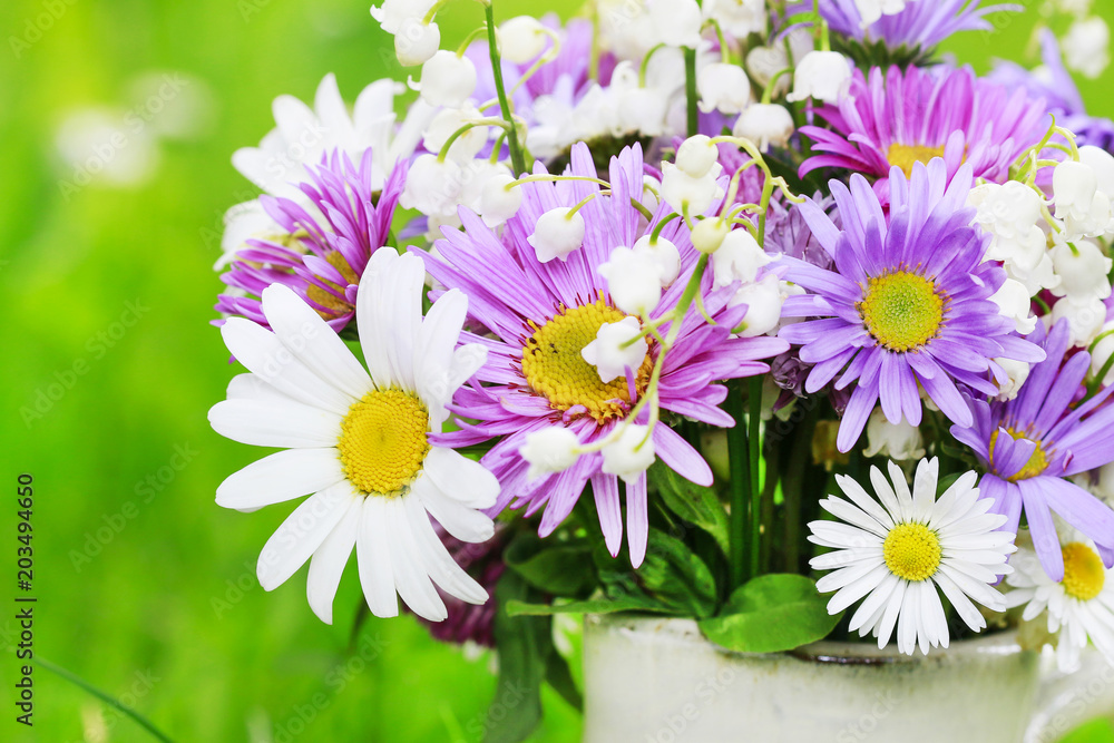 Fototapeta premium Cute bouquet of daisies, carnations, chamomile and lily of the valley flowers.