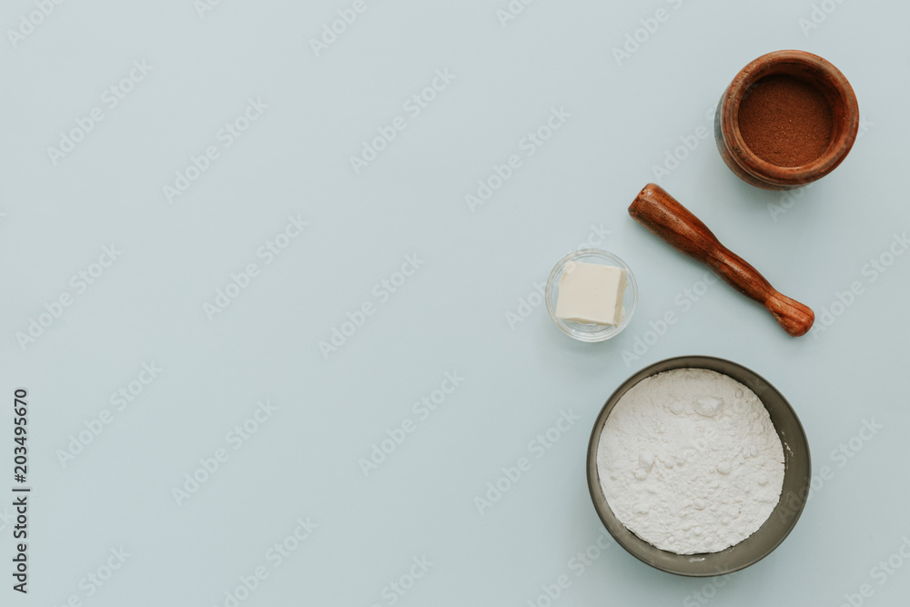 Flat lay with flour, butter and cocoa powder on pastel background. Baking concept Flat lay with flour, butter and cocoa powder on pastel background. Baking concept
