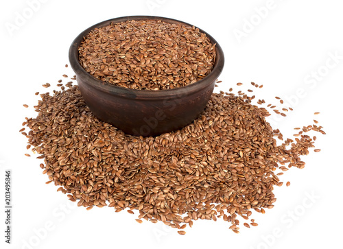 Flax seeds in ceramic bowl isolated on white background.
