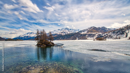 Engadine Valley. Spring thaw with islet on the lake photo