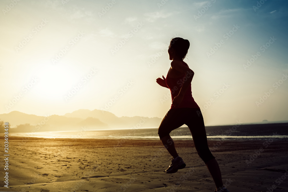 Healthy lifestyle woman running on the sunrise beach