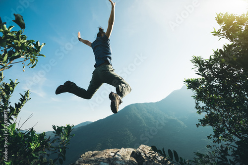 successful hiker with arms outstretched on sunrise mountain top
