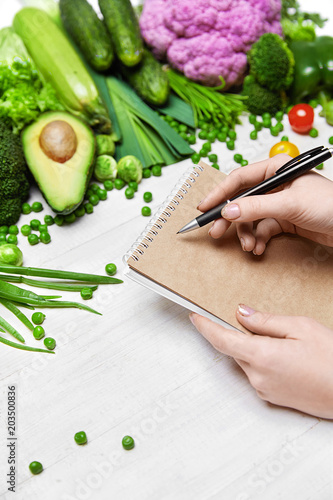 Diet Food. Woman Writing Product Plan On Paper