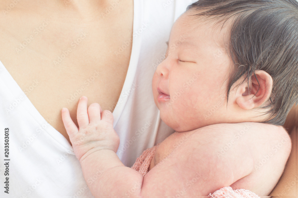 happy mother with baby in bed