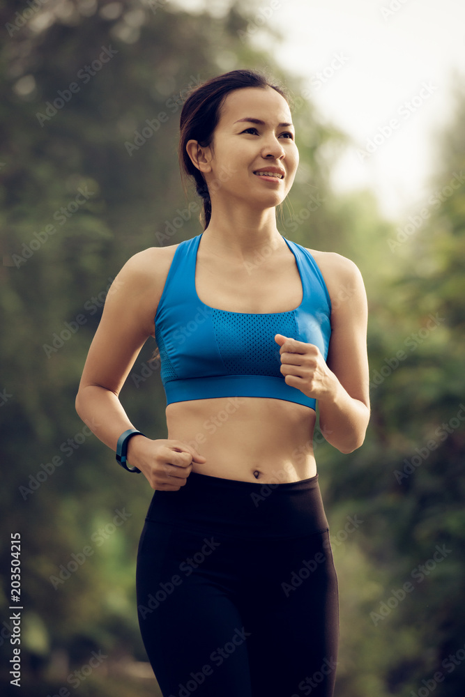 Fototapeta premium young sports woman runner running on road