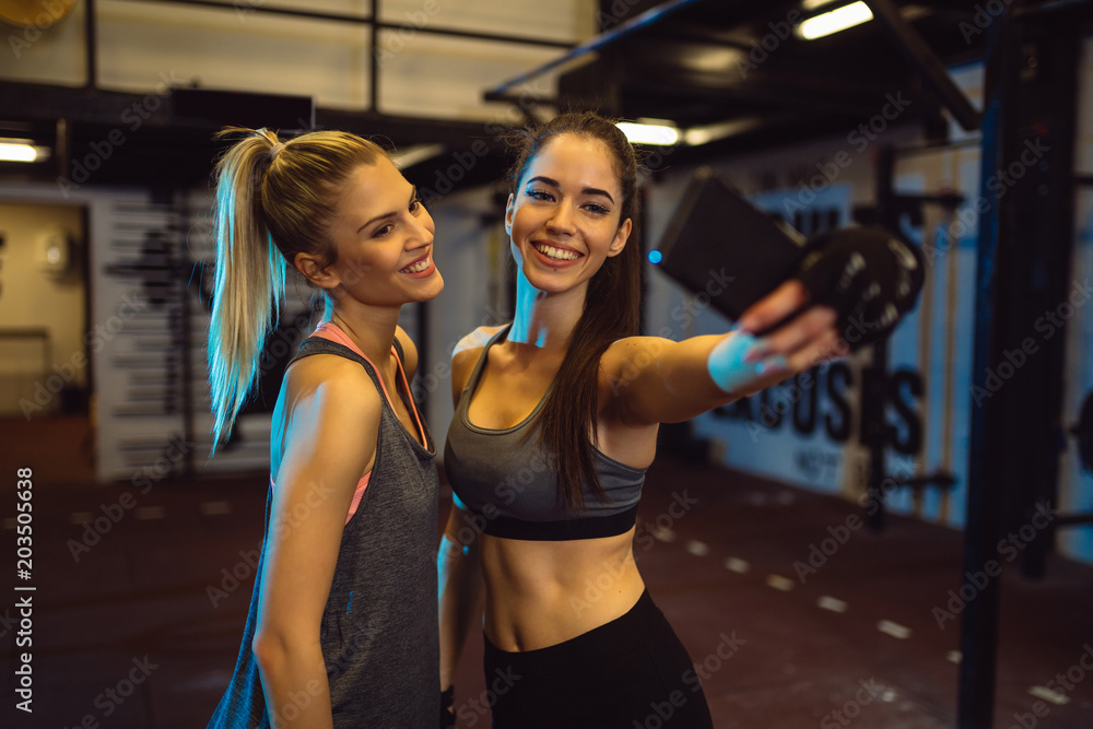 Girls are taking selfie during their training in a gym