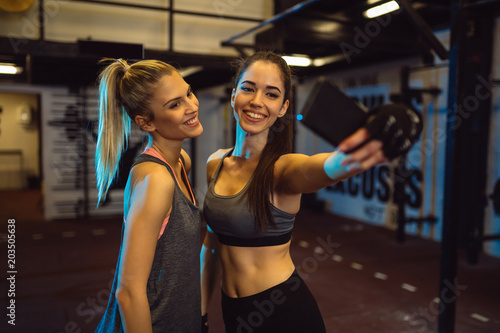 Girls are taking selfie during their training in a gym