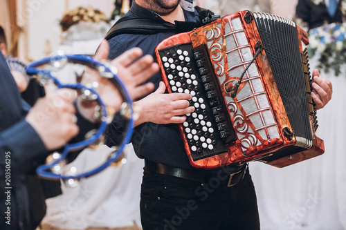 Konstfotografi musicians playing on accordion and tambourine, musical band performing at wedding reception