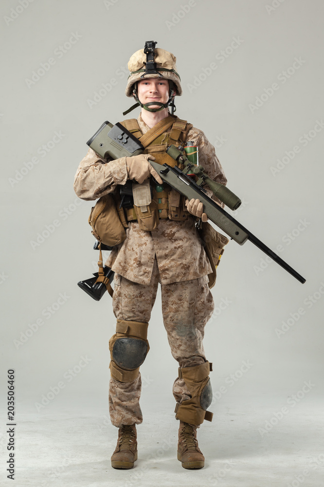 Soldier in camouflage holding rifle Soldier in camouflage holding rifle