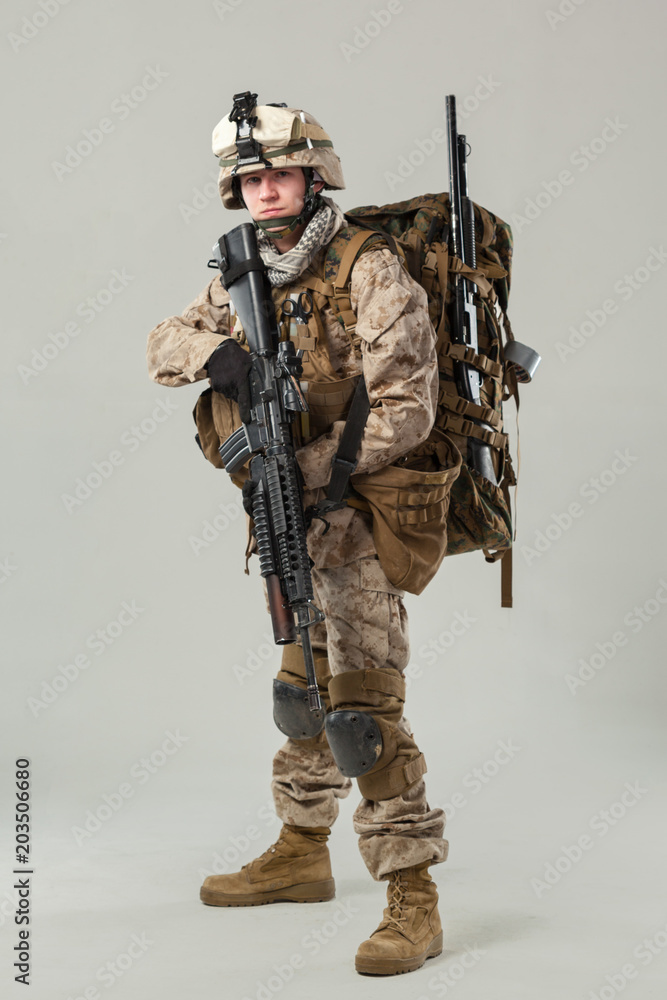 Obraz premium Soldier in camouflage holding rifle