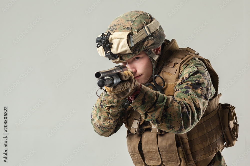 Fototapeta premium Soldier in camouflage holding rifle