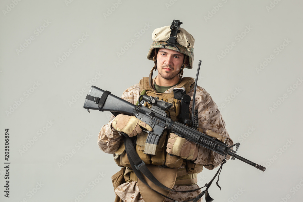 Soldier in camouflage holding rifle Soldier in camouflage holding rifle