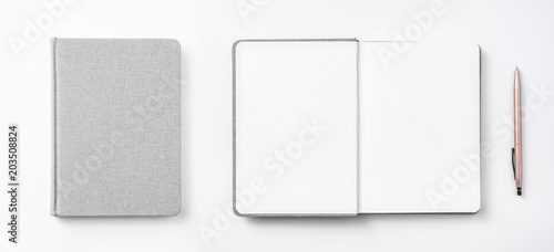 Design concept - Top view of hardcover gray linen notebook and ballpoint pen isolated on white background for mockup