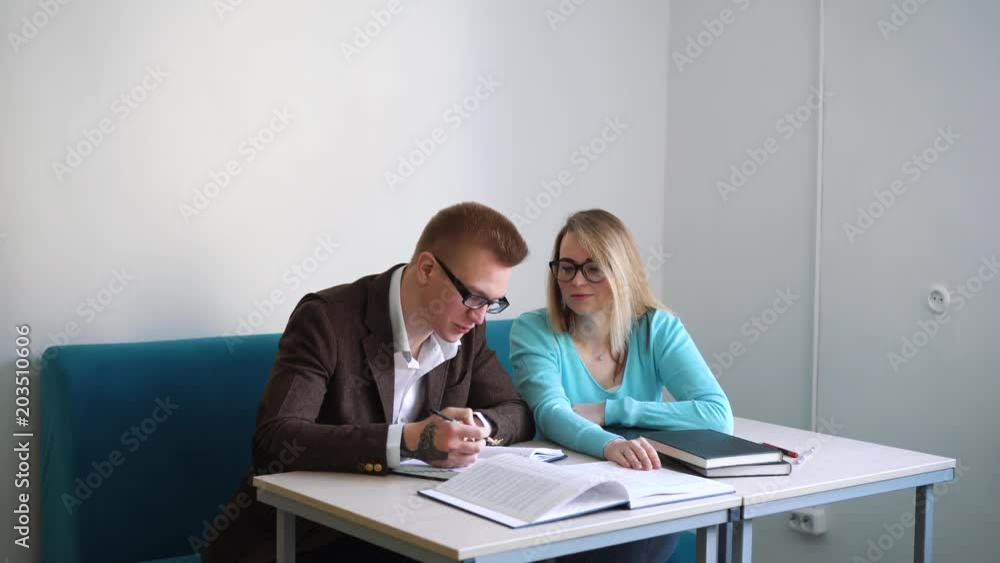 Portrait of two successful students casual stylish, boy and girl in library reading hall, evening time, education concept Portrait of two successful students casual stylish, boy and girl in library reading hall, evening time, education concept