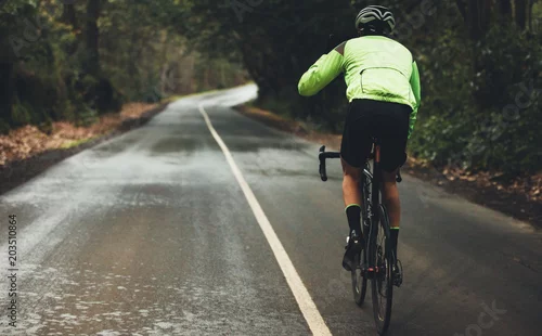 Fototapeta samoprzylepna Rowerzysta ćwiczy w deszczowy dzień