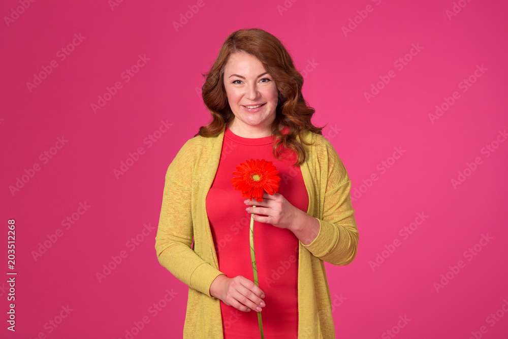 Beautiful adult woman with flowers on a pink background. Beautiful adult woman with flowers on a pink background.