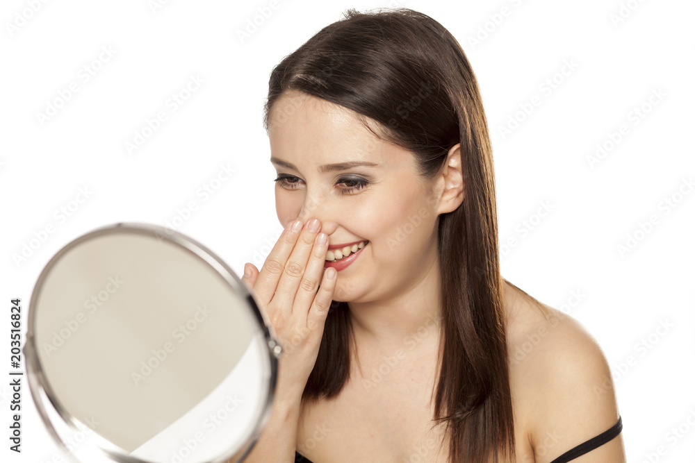 happy woman touches her nose on the mirror happy woman touches her nose on the mirror