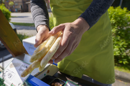 Spargelverkauf , der Verkäufer macht die Bestellung fertig 