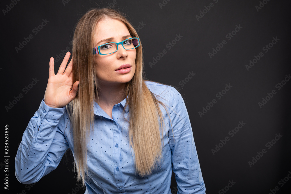 Business lady wearing blue glasses showing not hearing gesture. Business lady wearing blue glasses showing not hearing gesture.
