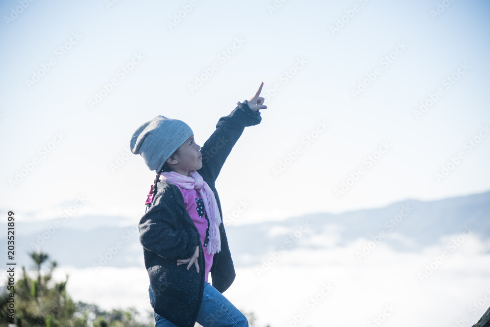 Child on the mountain top with arms up