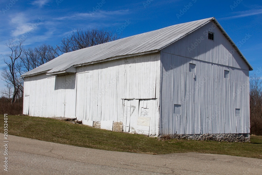 The old white barn in the country on a sunny day.
