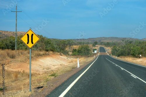Road narrows sign near road in the outback of Queensland in Australia