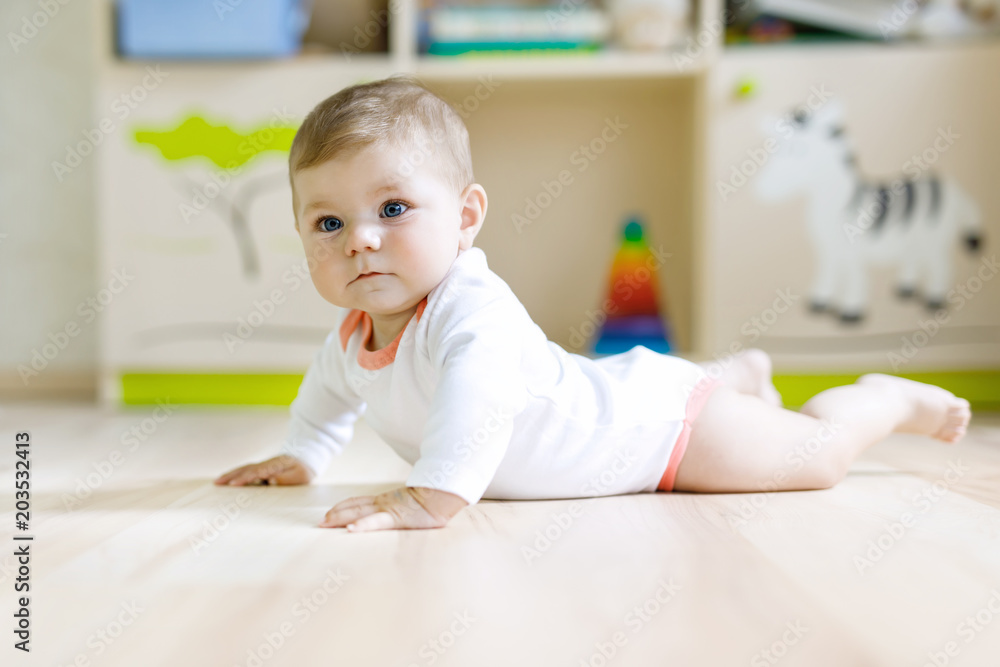 Fototapeta premium Cute baby girl learning crawling and sitting in children room