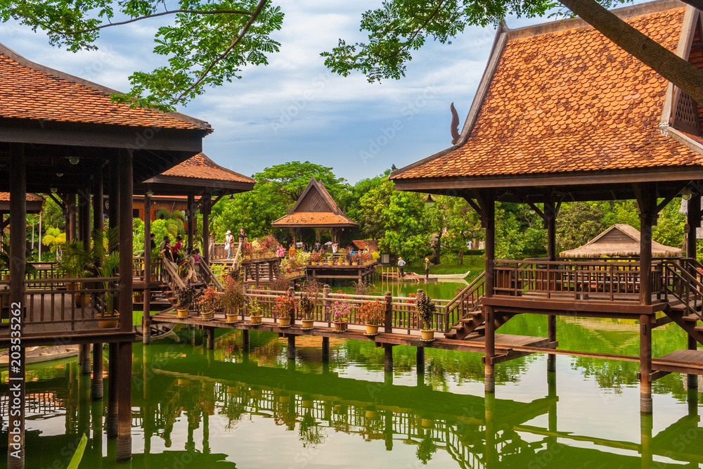 Fototapeta premium Piękny widok na pływającą wioskę w Cambodian Cultural Village w Siem Reap w Kambodży. Turyści lubią spacerować po drewnianych konstrukcjach na palach, które odbijają się w wodzie jeziora.