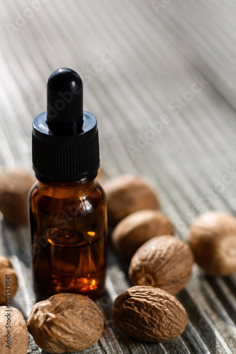 nutmeg essential oil on a gray wooden background