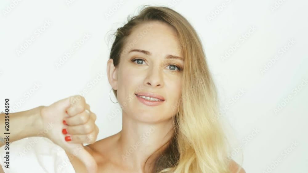 Attractive woman showing hand gesture thumb down on white background Attractive woman showing hand gesture thumb down on white background
