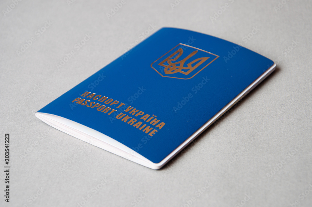 Foreign passport of Ukraine is isolated on a gray background with space for copying. Emigration from Ukraine to the European Union. Foreign passport of Ukraine is isolated on a gray background with space for copying. Emigration from Ukraine to the European Union.