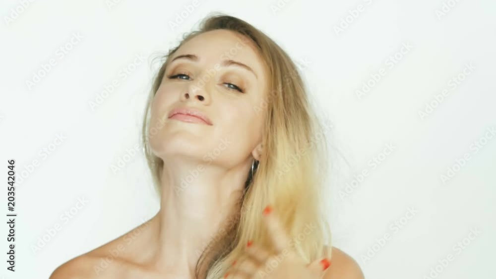 Happy woman touching volume hair and looking into camera Happy woman touching volume hair and looking into camera