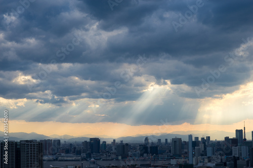 Top view of modern city with lights of sunset through clouds © Sean K