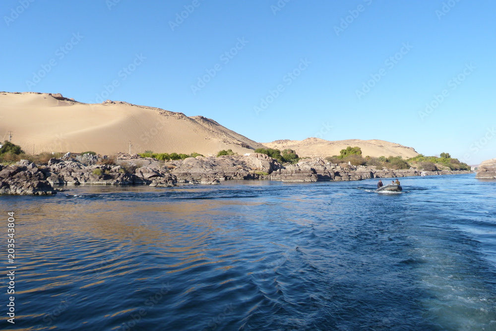 Wasser, Felsen und Sanddünen am Nilkatarakt bei Assuan.