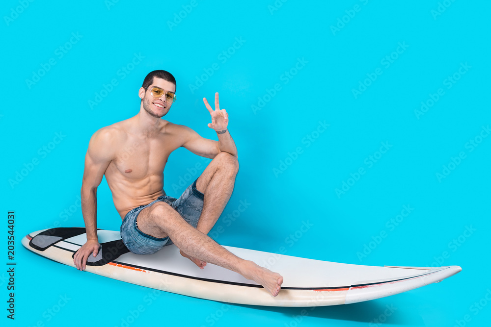 Cheerful surfer showing victory sign Cheerful surfer showing victory sign