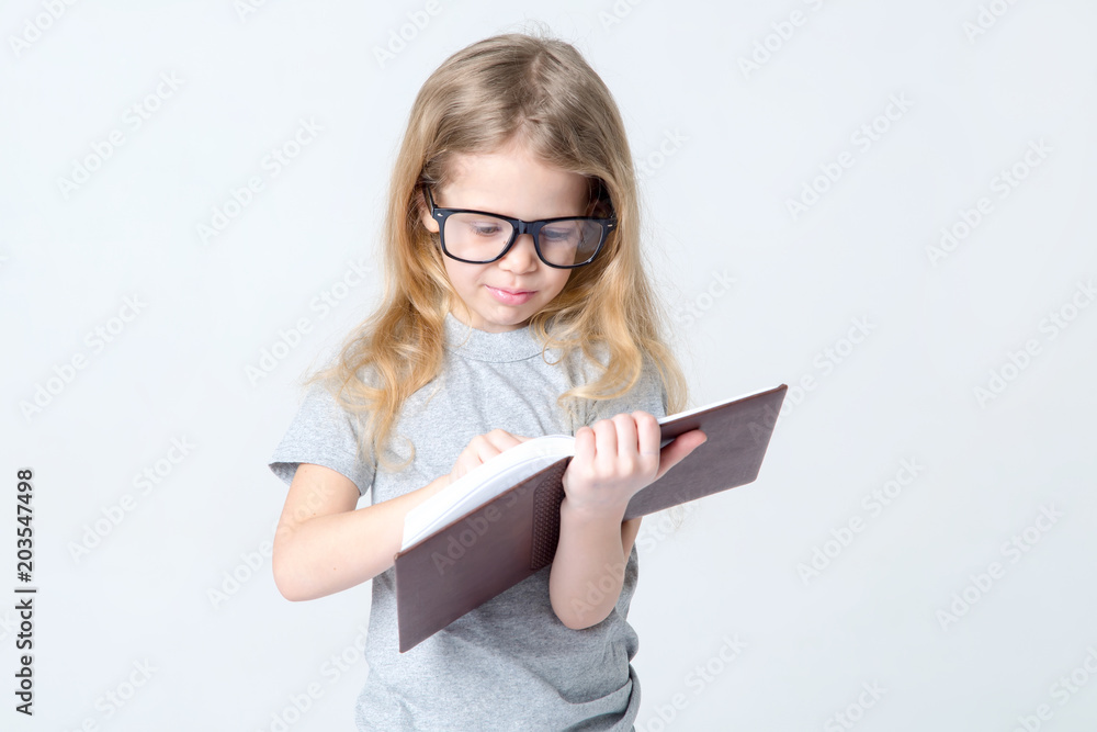 Little girl in glasses with a book in her hands. Little girl in glasses with a book in her hands.