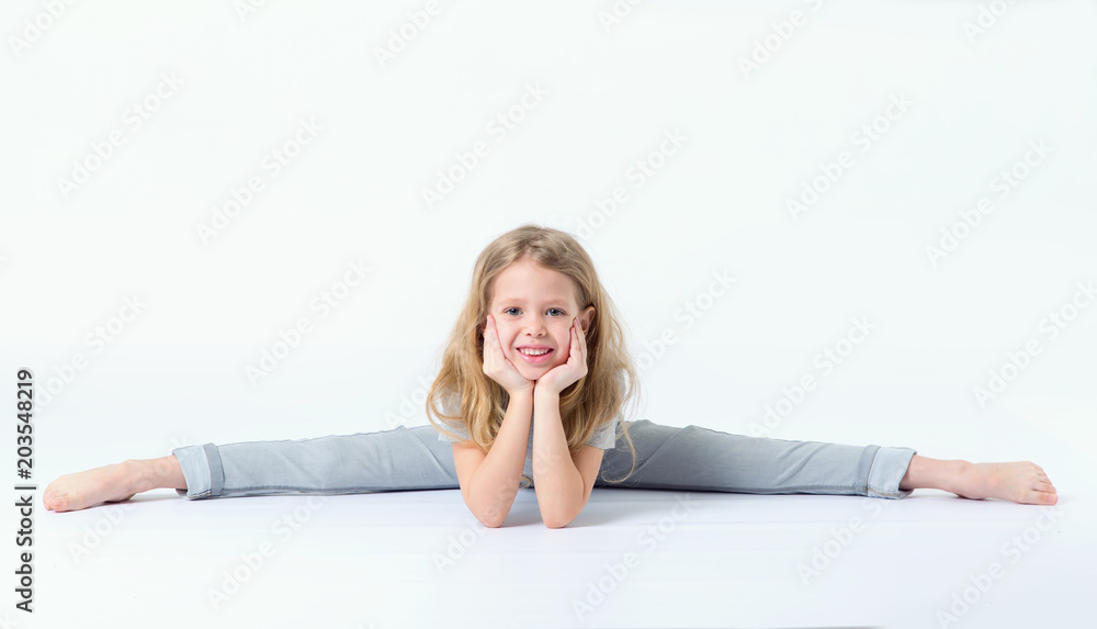 Little girl is sitting on a gymnastic twine. Little girl is sitting on a gymnastic twine.