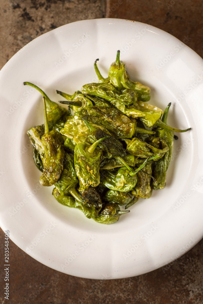 Grilled Padron Peppers in Rustic White Plate. Pimientos de Padron. Grilled Padron Peppers in Rustic White Plate. Pimientos de Padron.