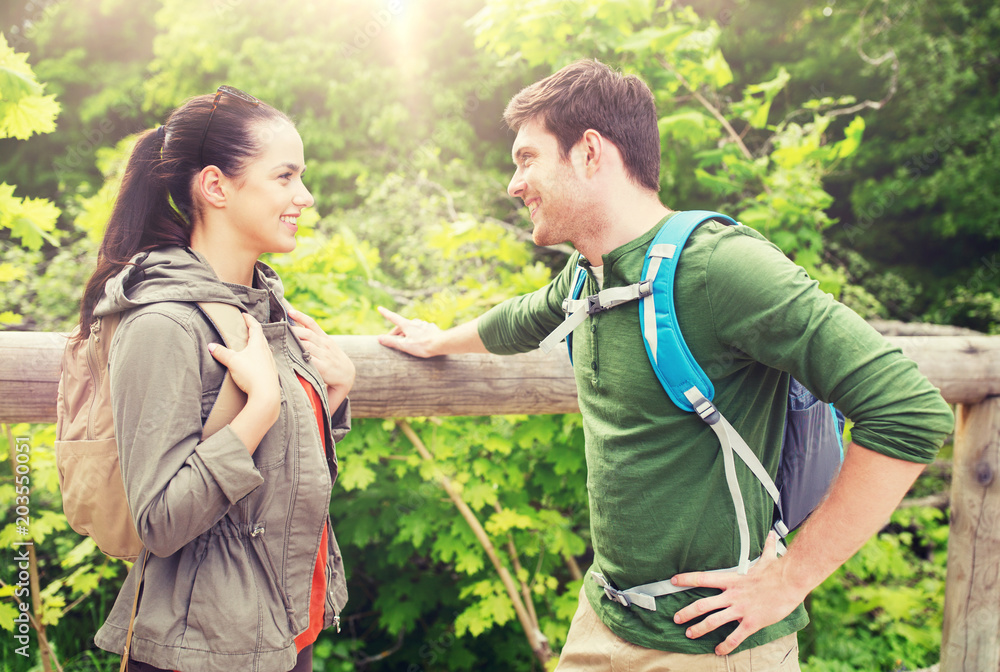 travel, hiking, backpacking, tourism and people concept - smiling couple with backpacks in nature travel, hiking, backpacking, tourism and people concept - smiling couple with backpacks in nature