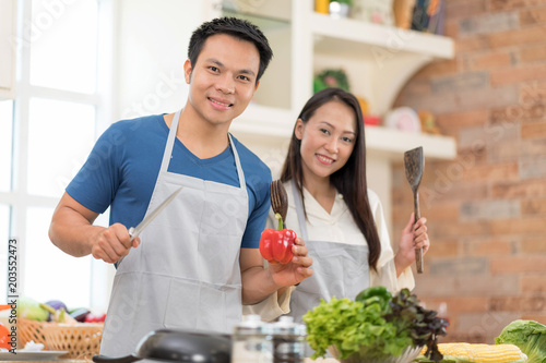 Portrait of happy young couple cooking together in the kitchen.Lover Hobby Lifestyle Concept.