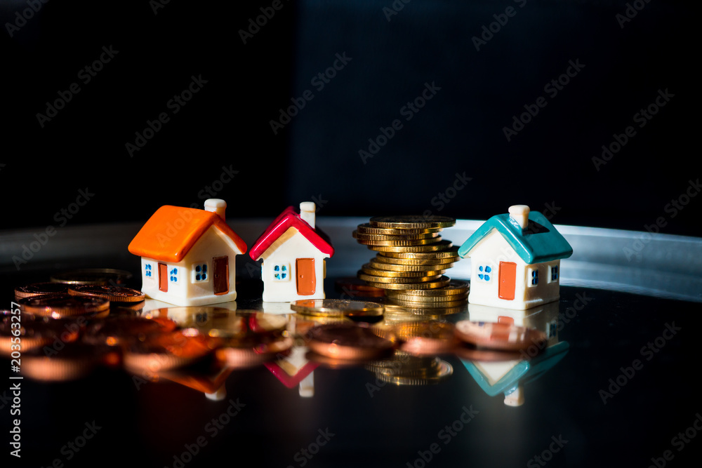 Miniature colorful house with golden stack coins using as business and property concept
