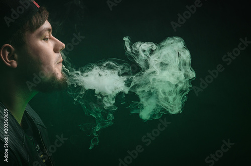 portrait of a guy Smoking electronic cigarettes. nicotine addiction. Jellyfish from smoke