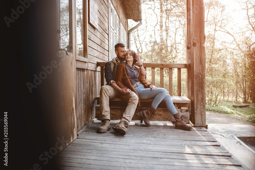 young couple hipster sitting on a bench on the terrace