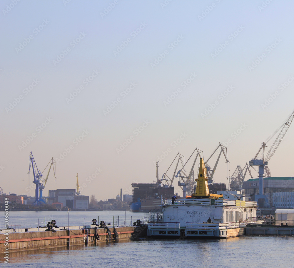 Industrial Port and Ship Factory with Cranes and Towers with Empty Sky Background. Container Cargo Ships in Operations, Freight Transportation Concept. Waterfront Factory and Sea Port View.