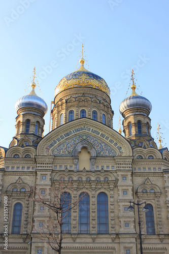 Church of the Assumption of Blessed Virgin Mary in St. Petersburg, Russia. Religious Russian Orthodox Cathedral Building, Exterior View with Facade and Domes from the Street with tree and Lantern. © onajourney
