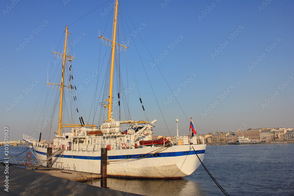 Sail Boat Moored on Water and Tied to Pier. Luxury White Ship on Waterfront Embankment in St Petersburg, Russia. Vintage Yacht or Cruise Ship at Marina Lot before Sunset with Empty Sky Background.