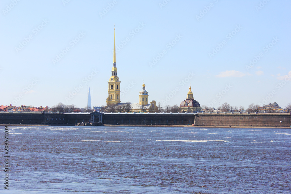 Obraz premium Peter and Paul Fortress in Saint Petersburg City, Russia. Scenic Outdoors View of Popular Tourist Landmark with Neva River Water with melting Ice and Sky Background on Sunny Spring Day Landscape. 