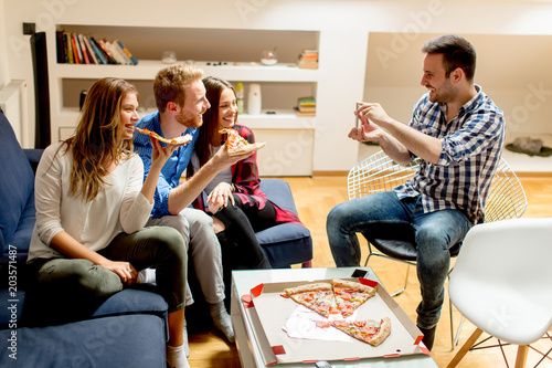Young friends eating pizza ...