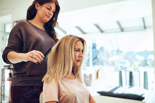 Young blonde woman getting her hair done at the salon