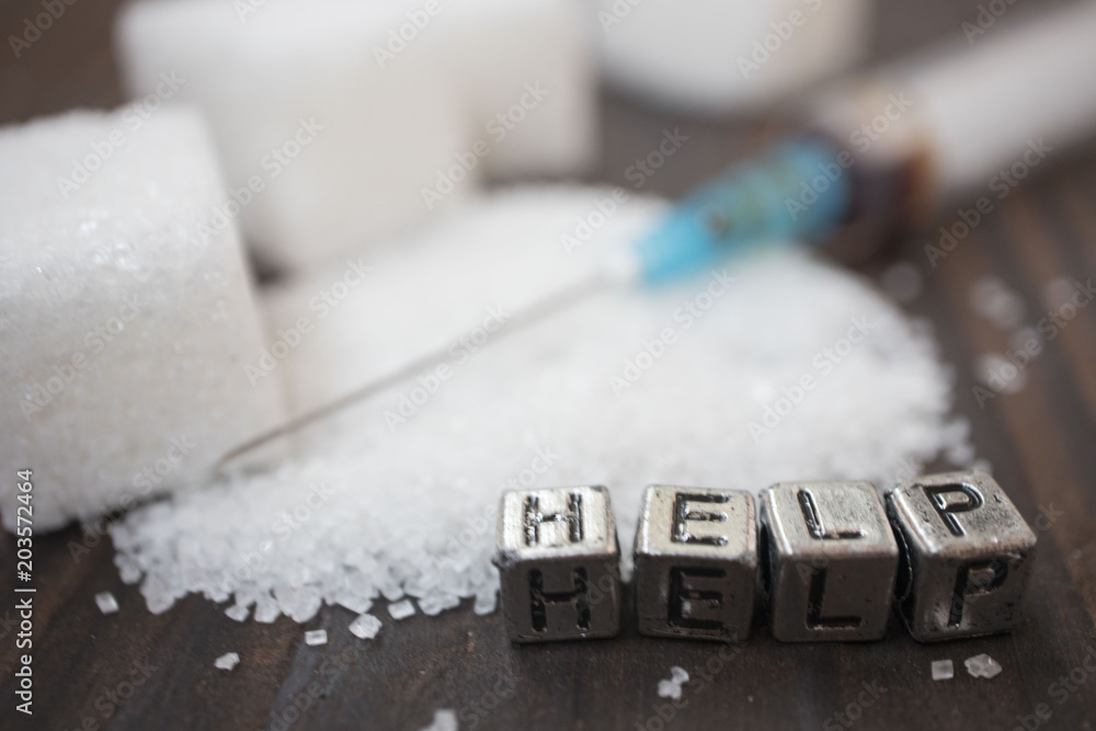 syringe, white sugar and inscription-help on a wooden background, concept of diabetes syringe, white sugar and inscription-help on a wooden background, concept of diabetes